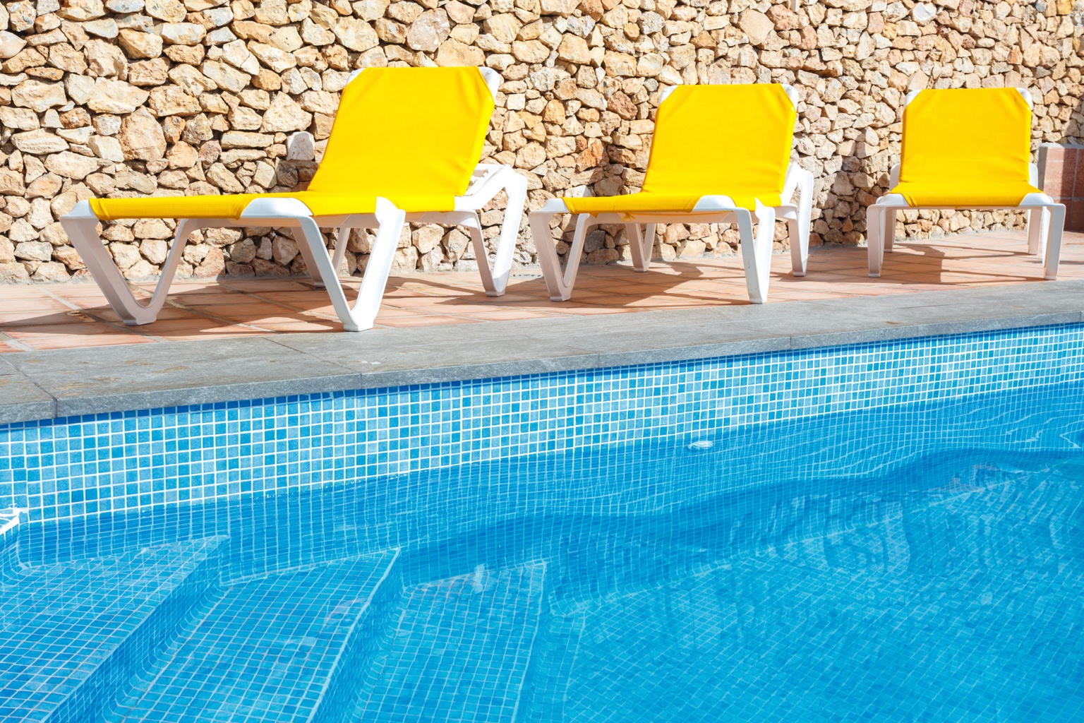 Poolside loungers with yellow cushions